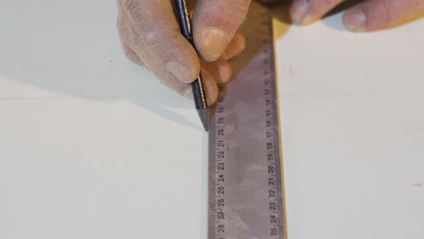 Carpenter's-Hands-Measures-the-board-with-a-ruler.